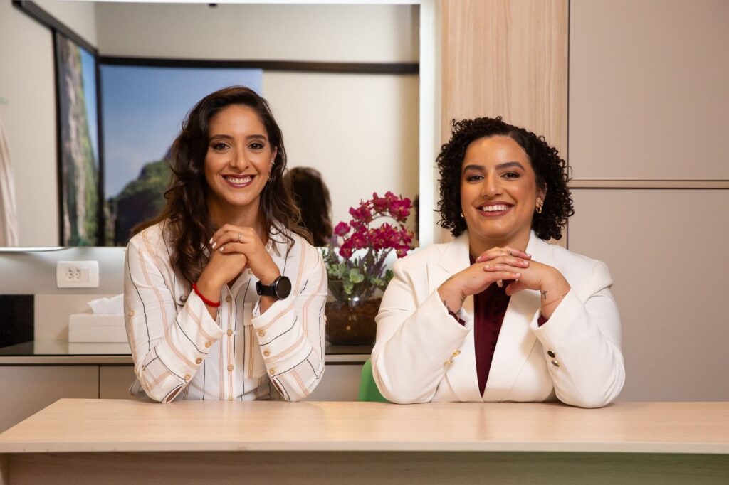 Fisioterapeutas sorridentes, em uma sala com pareces off white. Ilustração do texto sobre benefícios do pilates para atletas